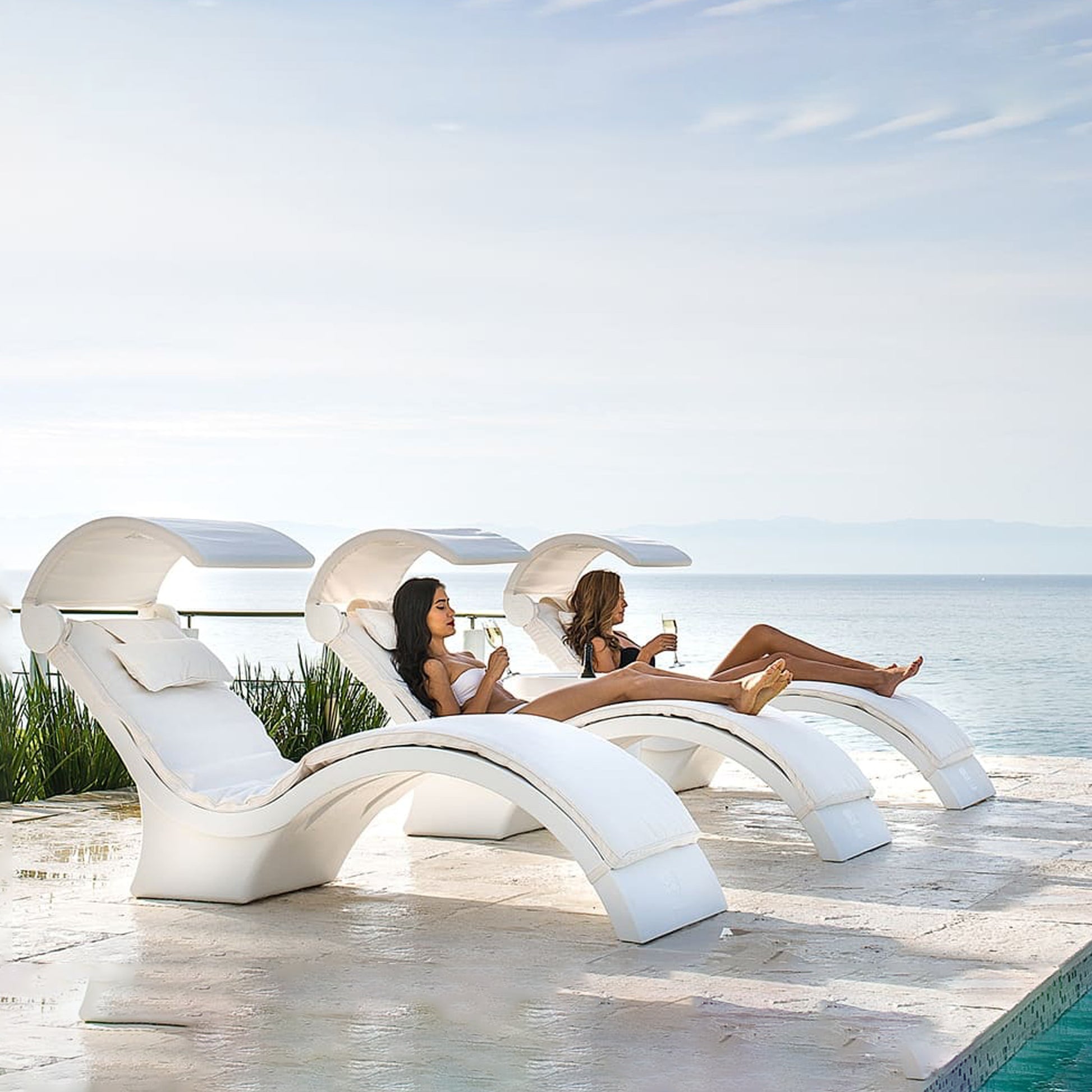 Women relaxing in Ledge Lounger Signature Chaise Deep Chairs